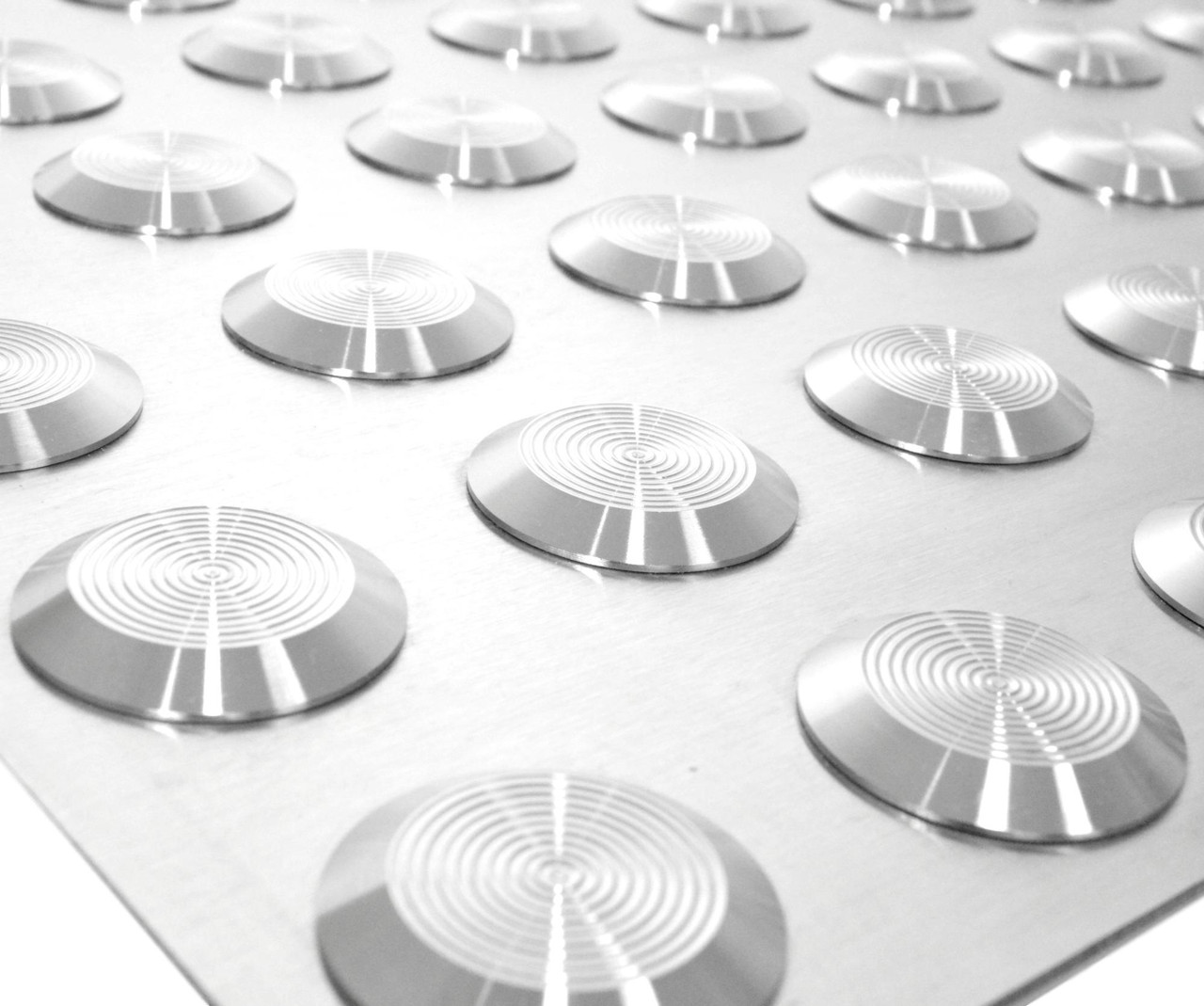 Macro detail of dome studs showing concentric tactile rings on polished stainless steel